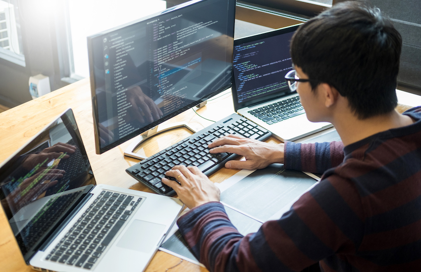 Pensive programmer working on on desktop pc programming code technologies or website design at office Software Development Company Pensive programmer working on on desktop pc programming code technologies or website design at office Software Development Company.